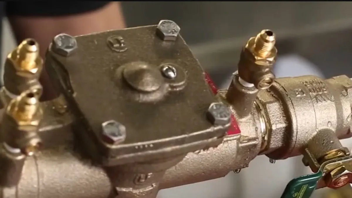 compact brass backflow preventer is shown between threaded pipe connections for backflow testing & prevention in maricopa, az in Maricopa