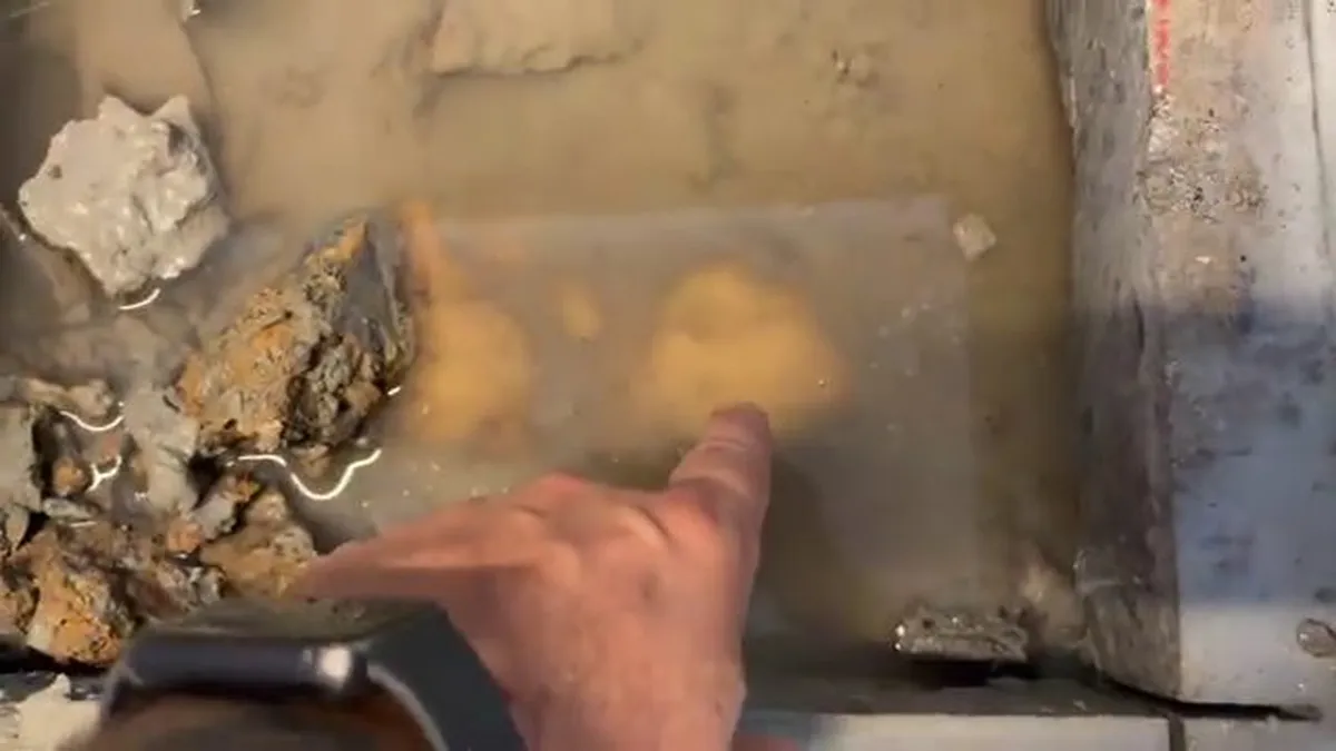 Murky water fills a small slab opening around an exposed leaking line for burst pipe repair in maricopa, az in Maricopa