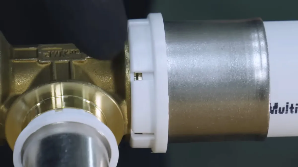 brass fitting and white plastic pipe are aligned for a new plumbing connection during a plumbing service call in Maricopa, AZ