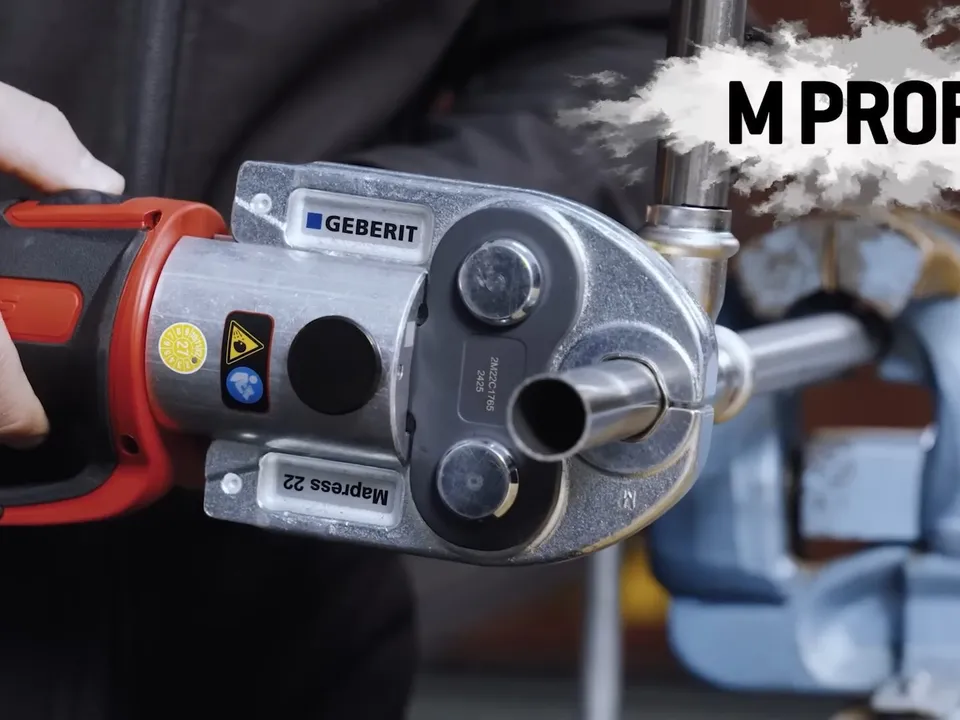 powered press tool grips a metal pipe fitting during assembly during a plumbing service call in Maricopa, AZ