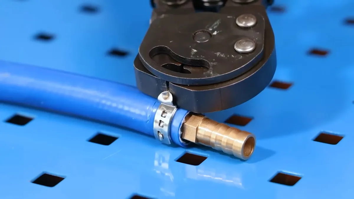 crimping tool secures a metal ring around blue flexible water tubing during a plumbing service call in Maricopa, AZ