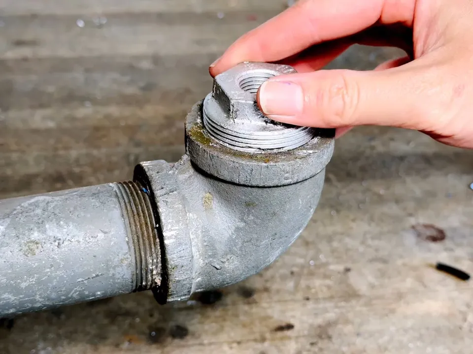 threaded cleanout cap is removed from a gray cast iron fitting for drain cleaning & unclogging in maricopa, az in Maricopa
