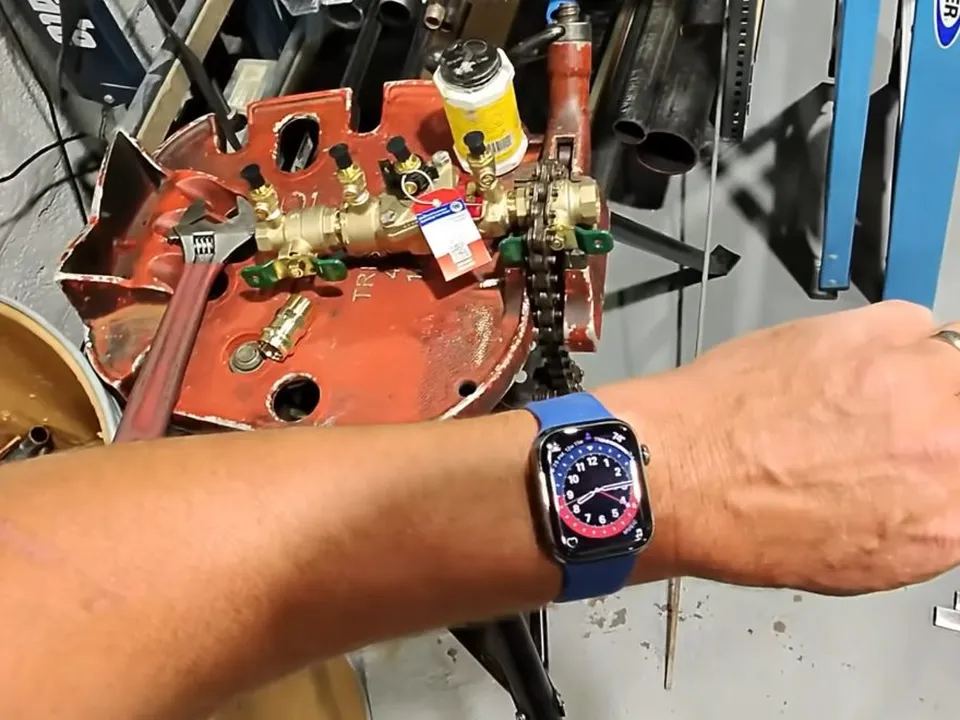 test gauge is connected to a backflow preventer for a pressure check during a plumbing service call in Maricopa, AZ