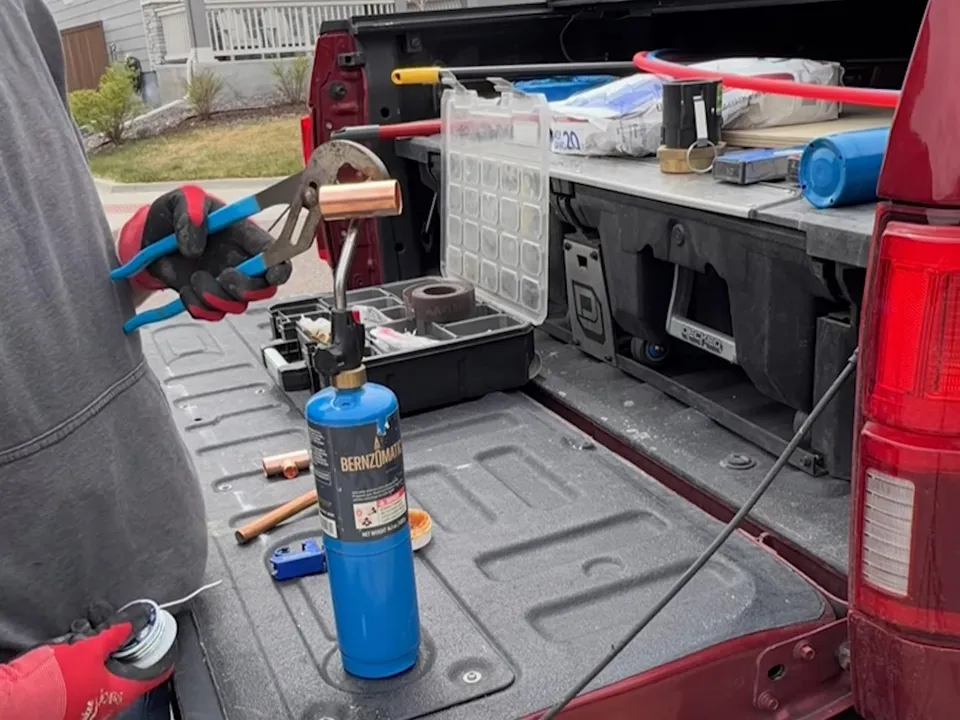 Pipe tools, fittings, and a torch are organized on the tailgate of a service truck for 24/7 emergency plumber in maricopa, az in Maricopa
