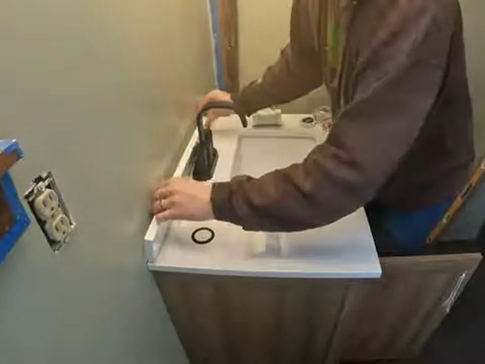 compact wall-mounted sink is lifted away from its plumbing connections for faucet & sink repair in maricopa, az in Maricopa