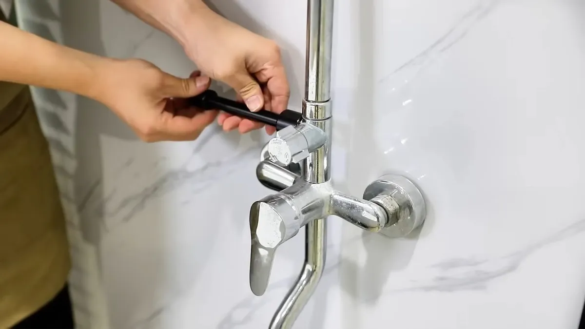 hand tightens the trim connection on a wall-mounted faucet for faucet & sink repair in maricopa, az in Maricopa