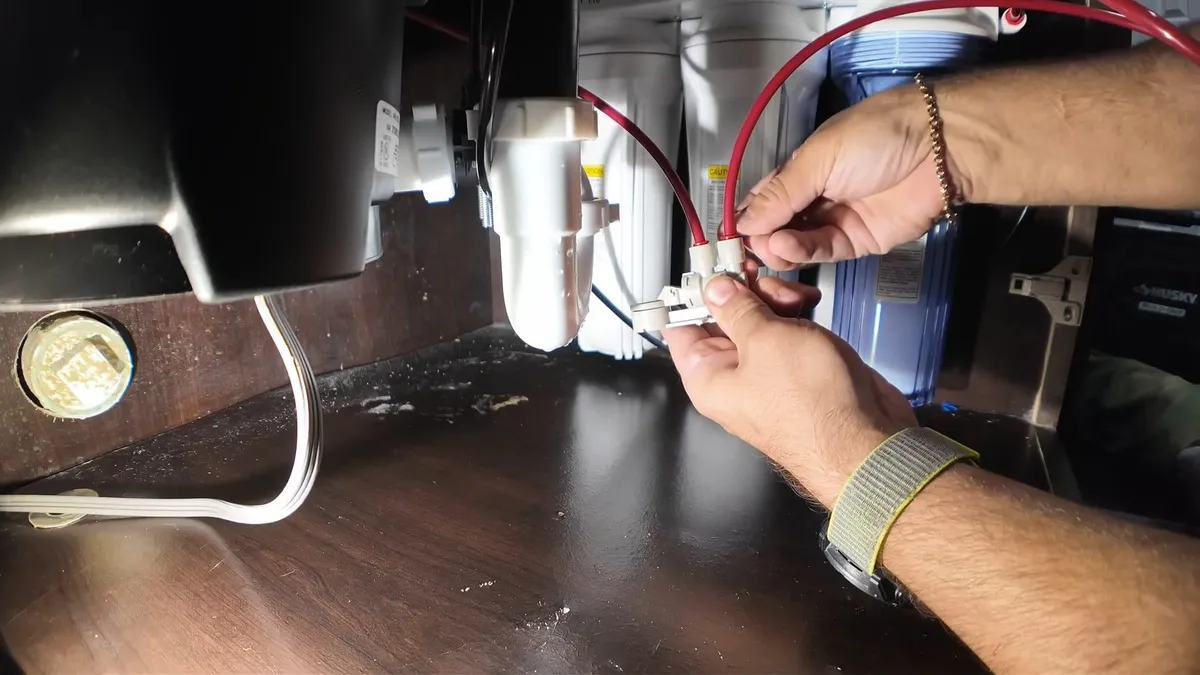 Filter tubing and small valves are connected beneath a kitchen sink for garbage disposal repair & installation in maricopa, az in Maricopa