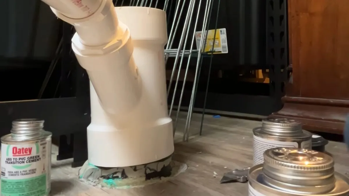 White PVC drain fittings are dry-fitted at the base of a utility sink for garbage disposal repair & installation in maricopa, az in Maricopa