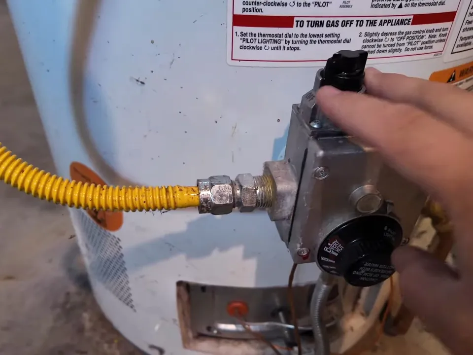 yellow gas connector is secured to the control valve on a tank water heater for gas line installation & repair in maricopa, az in Maricopa