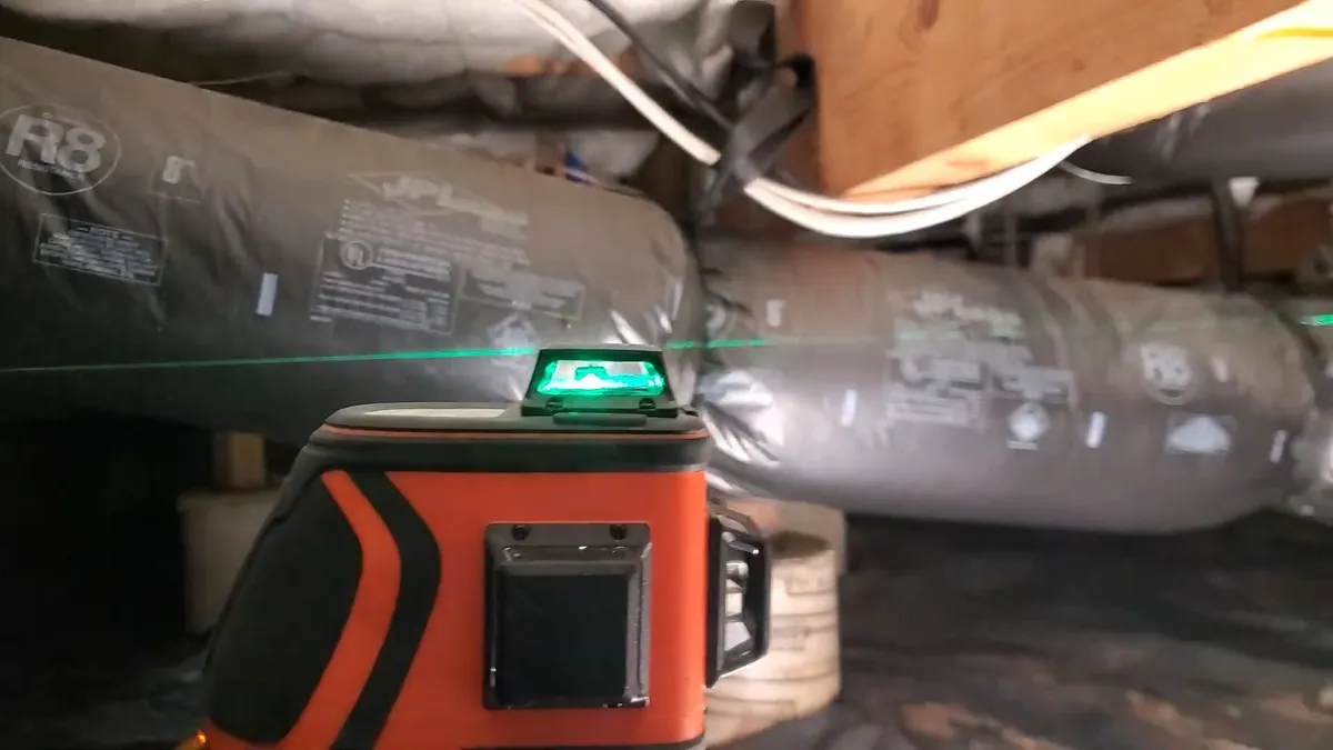 laser level checks the pitch of a horizontal drain line beneath a floor during a plumbing service call in Maricopa, AZ