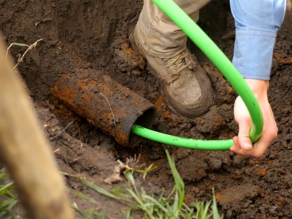 bright green lining hose is fed into an underground sewer connection for hydro jetting in maricopa, az in Maricopa
