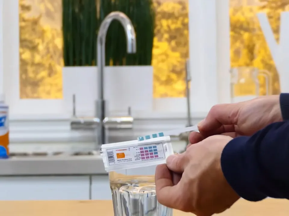 handheld digital meter checks a fresh glass of tap water illustrating How Hard Is Maricopa's Water from Global Water Resources? A Homeowner's Guide