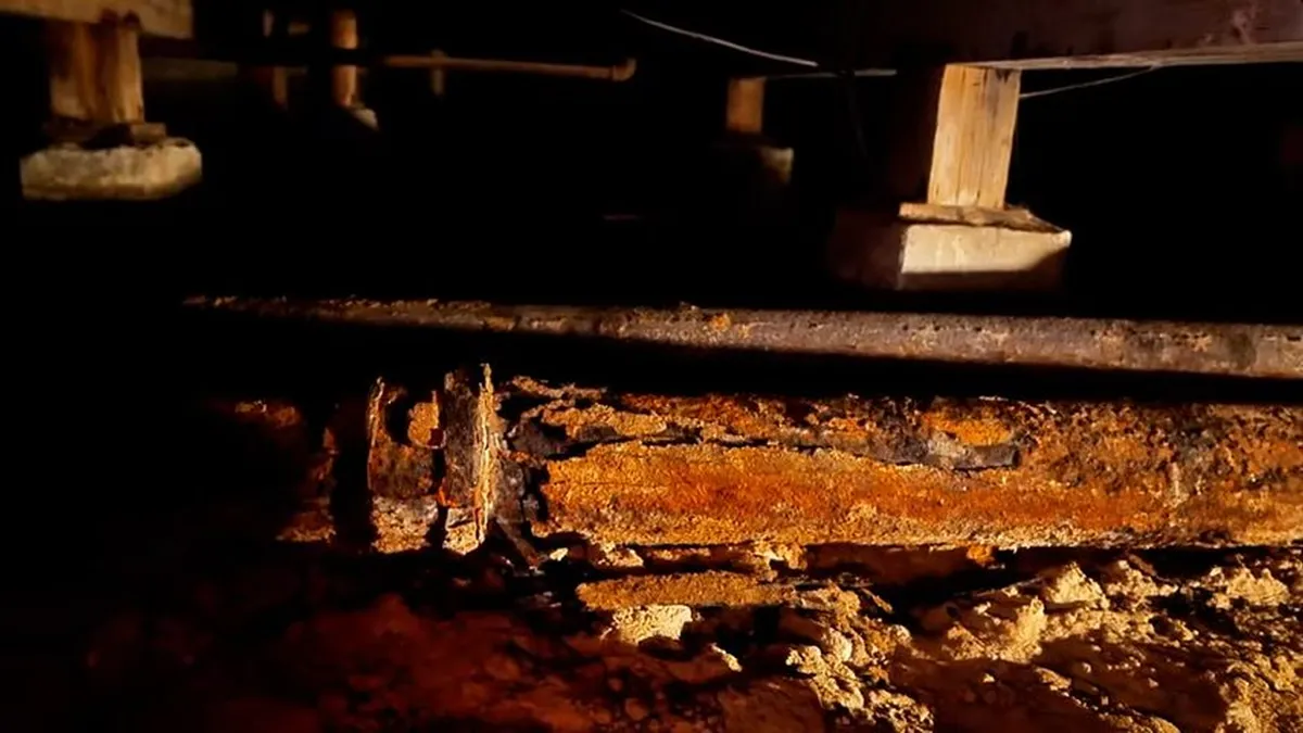 heavily corroded horizontal sewer pipe is exposed beneath a building during a plumbing service call in Maricopa, AZ