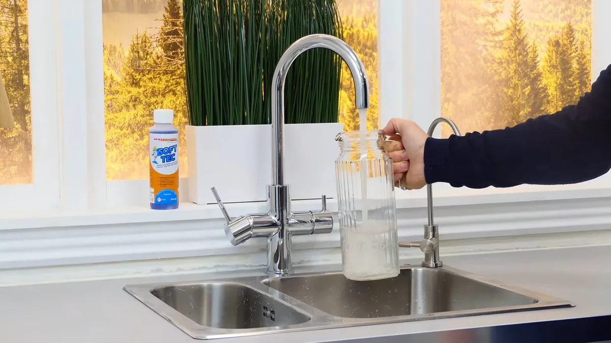 clear water sample is collected from a kitchen faucet for testing during a plumbing service call in Maricopa, AZ