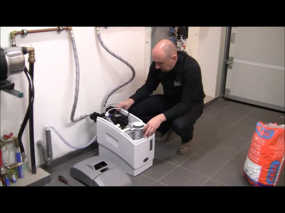 technician programs a residential water-softener control panel during a plumbing service call in Maricopa, AZ