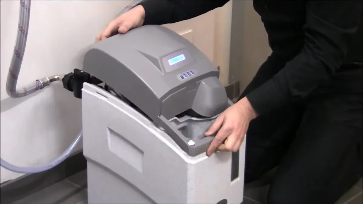 top cover of a gray water softener is opened for setup and service during a plumbing service call in Maricopa, AZ