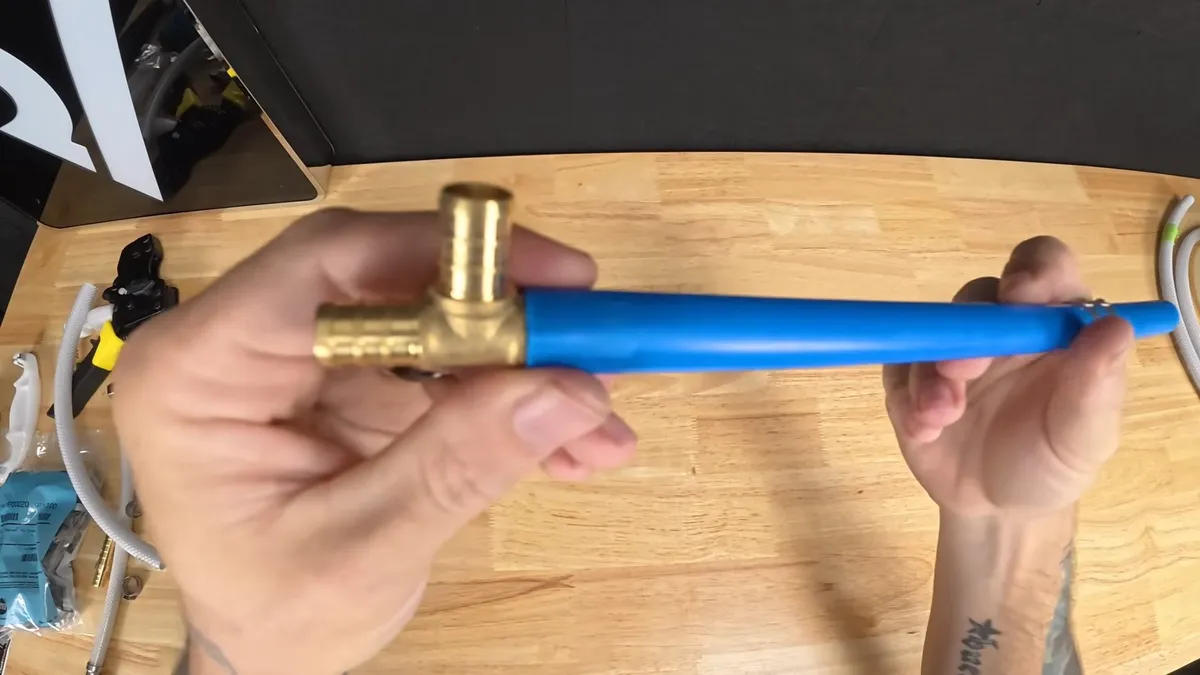 blue flexible water line is inserted into a brass tee fitting for repiping & whole-home pipe replacement in maricopa, az in Maricopa