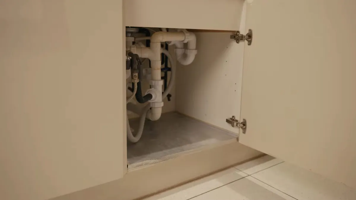 open sink cabinet shows the drain and supply connections before a filter is added for reverse osmosis installation in maricopa, az in Maricopa