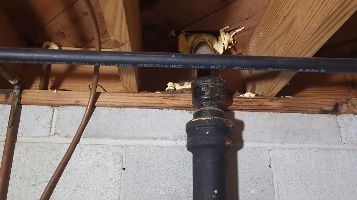 black cast iron branch connects to a newer white PVC drain beneath a floor for sewer line repair in maricopa, az in Maricopa