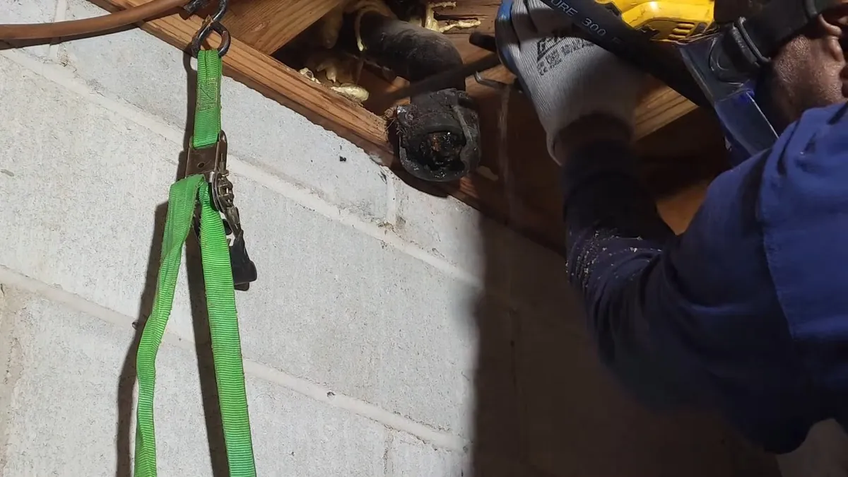 plumber works below a framed floor while replacing an old cast iron section for sewer line repair in maricopa, az in Maricopa