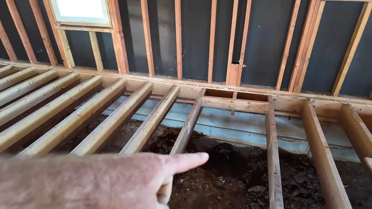old cast iron septic line is exposed between floor joists for sewer line replacement in maricopa, az in Maricopa