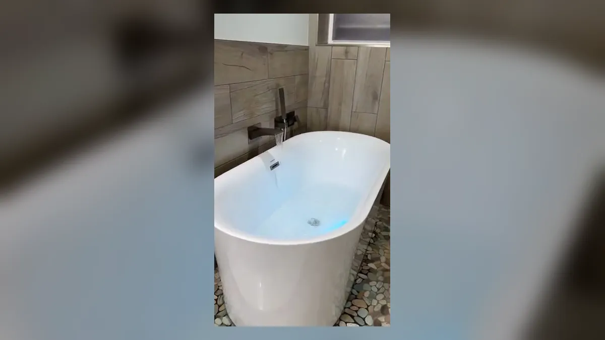 freestanding white bathtub is installed against large-format wall tile for shower & bathtub installation in maricopa, az in Maricopa