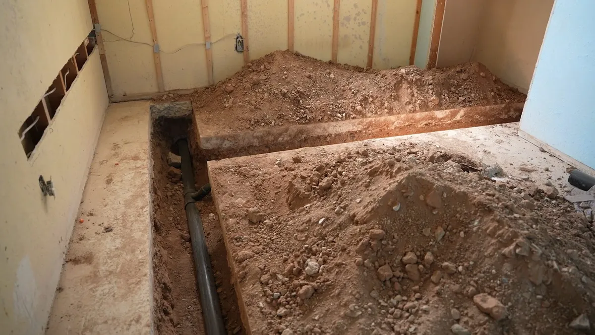 bathroom floor is excavated to reach buried drain piping illustrating Slab Leak Repair in Maricopa: Spot Repair, Pipe Rerouting, or Epoxy Lining?