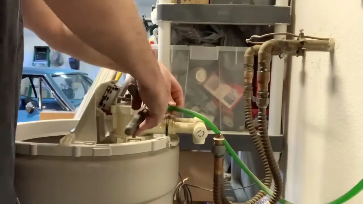 water-softener tank is serviced beside its attached tubing and control head during a plumbing service call in Maricopa, AZ