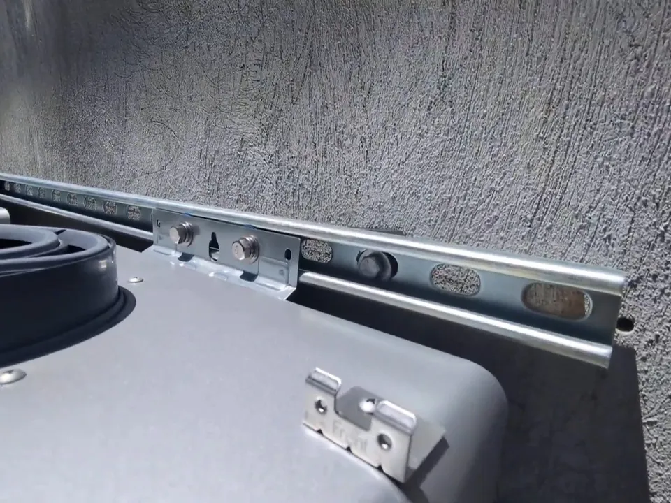 outdoor tankless heater mounting rail is fastened to a stucco wall during a plumbing service call in Maricopa, AZ