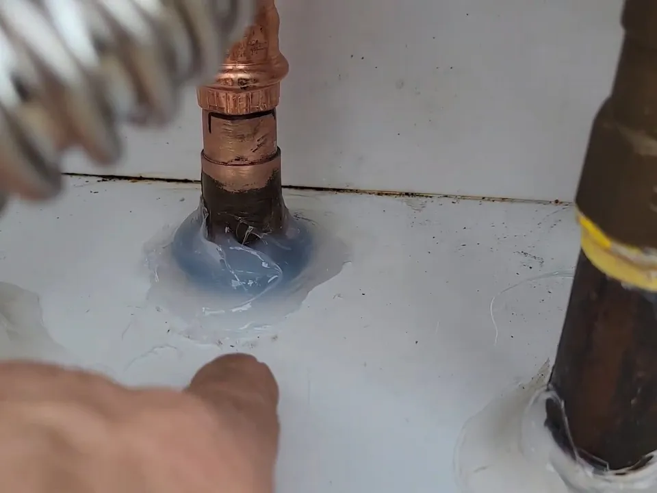 Copper water, gas, and condensate lines connect beneath an outdoor tankless unit illustrating Tank vs. Tankless Water Heater in Maricopa, AZ: What to Know Before You Switch