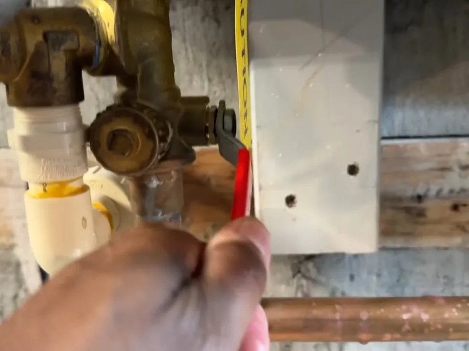 screwdriver adjusts a service valve beneath a wall-mounted tankless unit for tankless water heater services in maricopa, az in Maricopa