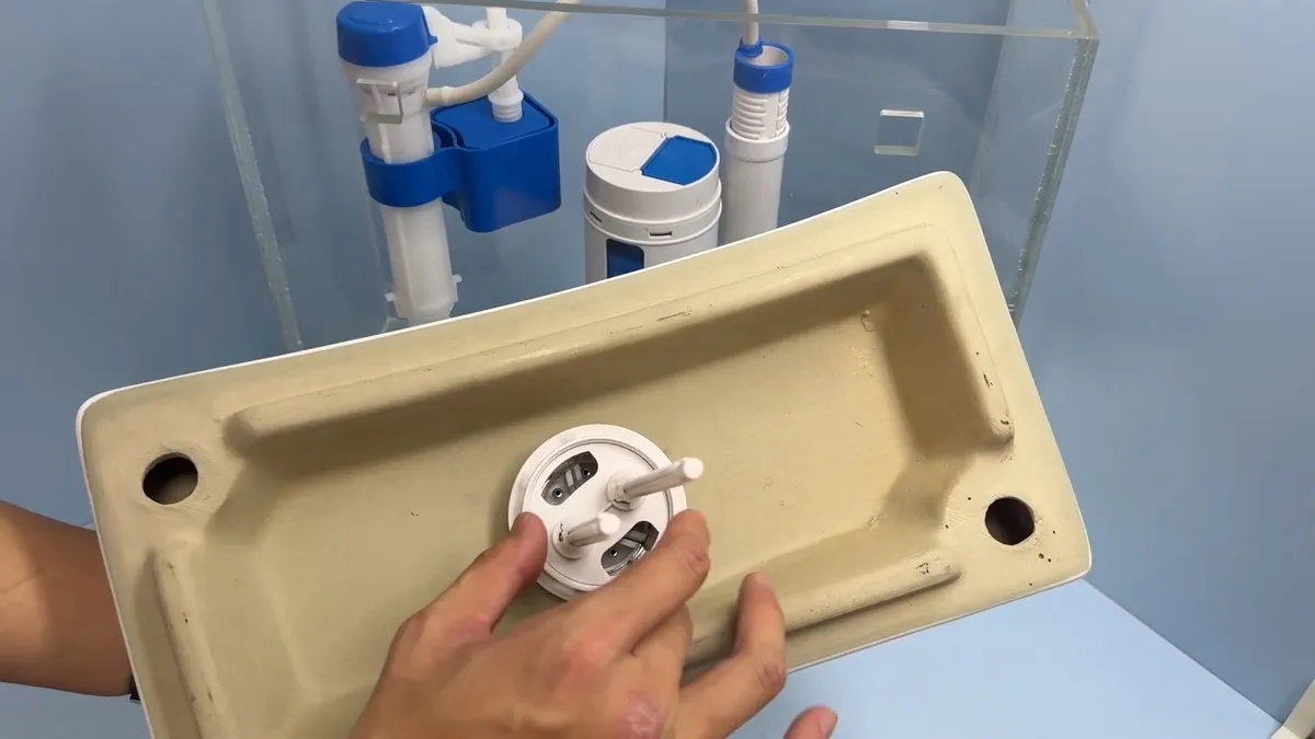 flush valve seal and mounting hardware are examined beneath a toilet tank lid for toilet repair & installation in maricopa, az in Maricopa