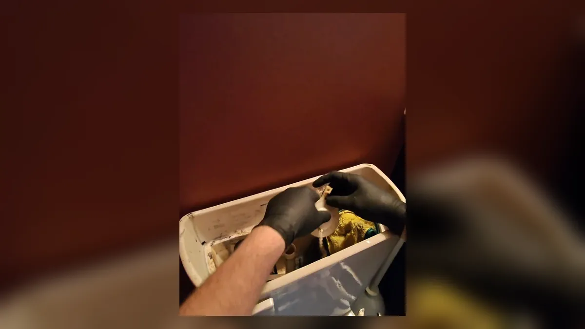 hand reaches into a toilet tank while replacing internal repair parts for toilet repair & installation in maricopa, az in Maricopa