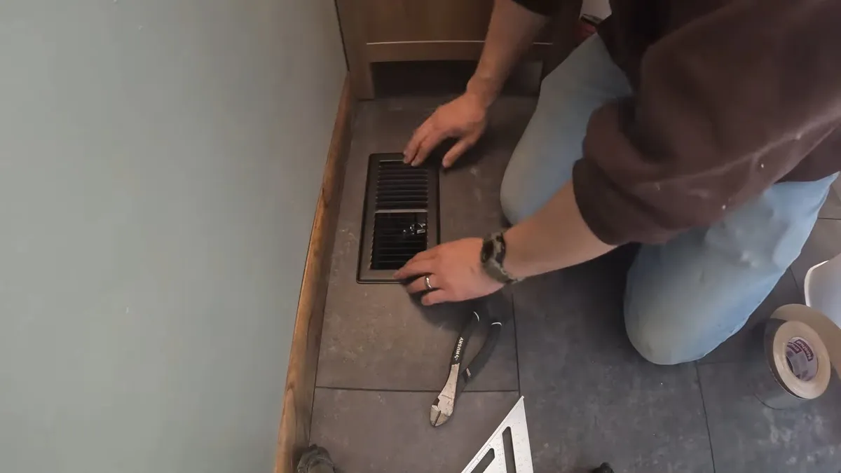 rectangular floor opening is measured beside finished tile during an inspection illustrating Warm Spot on Your Floor? How to Tell If Your Maricopa Home Has a Slab Leak
