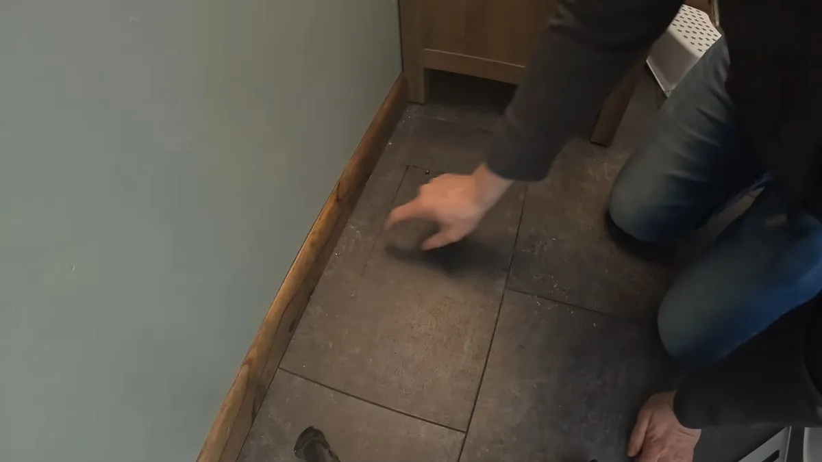 technician checks a tiled floor where a warm area has been reported illustrating Warm Spot on Your Floor? How to Tell If Your Maricopa Home Has a Slab Leak