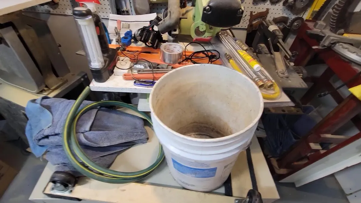 bucket, hose, and pump are arranged for water-heater flushing for water heater installation & replacement in maricopa, az in Maricopa