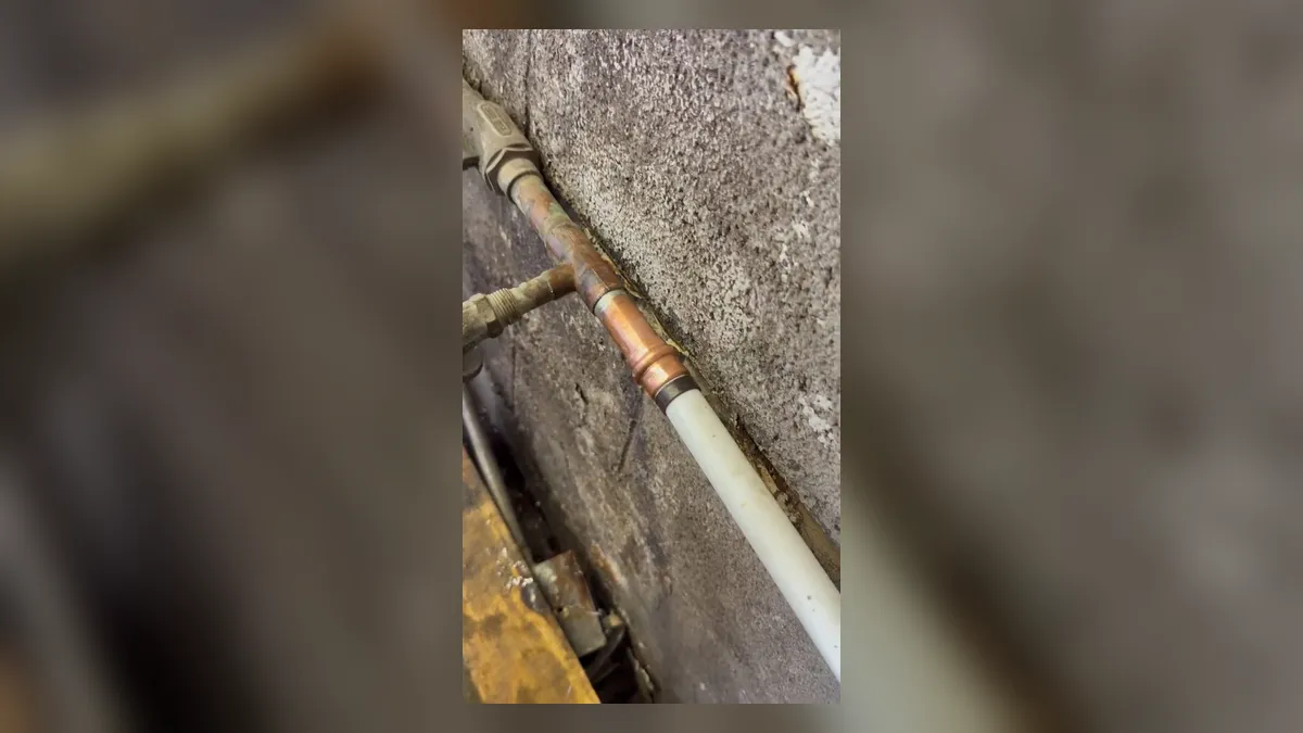 new white pipe section is joined to an older copper line in a wall opening for water line repair & replacement in maricopa, az in Maricopa