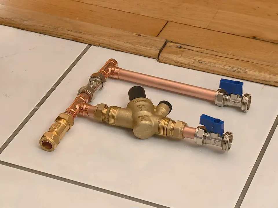 brass bypass valve assembly is laid out with blue shutoff handles illustrating Water Softener Installation Cost in Maricopa, AZ: 2025 Price Guide